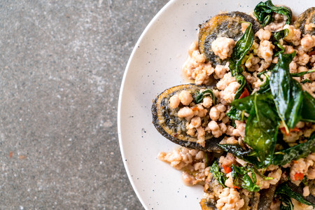 Stir-fried Century Egg and Minced Pork with Holy Basil Leaves on plateの写真素材