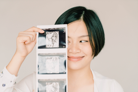Young beautiful Asian pregnant woman with ultrasound film - selective focus point and vintage  styleの写真素材