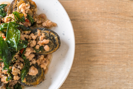 Stir-fried Century Egg and Minced Pork with Holy Basil Leaves on plateの写真素材