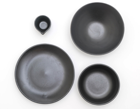 empty black plate and bowl isolated on white backgroundの写真素材