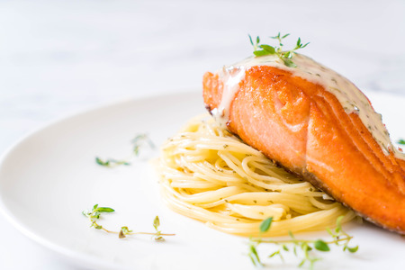 spaghetti with fried salmon on plateの写真素材