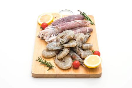 fresh seafood raw (shrimps ,squids) on wooden board isolated on white backgroundの写真素材