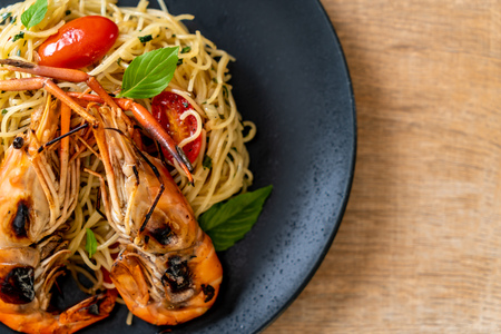 stir-fried spaghetti with grilled shrimps and tomatoes - Italian fusion food styleの写真素材