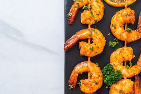 Grilled tiger shrimps skewers with lemon - seafood styleの写真素材