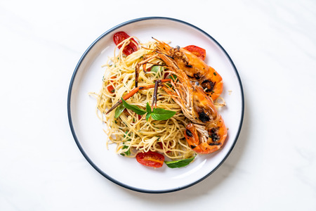 stir-fried spaghetti with grilled shrimps and tomatoes - Italian fusion food styleの写真素材
