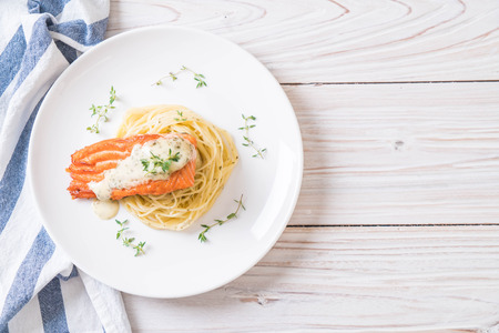 spaghetti with fried salmon on plateの写真素材