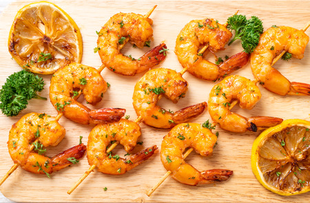 Grilled tiger shrimps skewers with lemon - seafood styleの写真素材