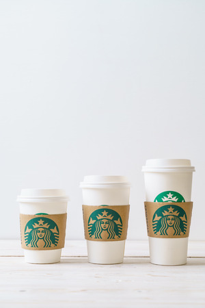 BANGKOK, THAILAND - JUN 5, 2018: White coffee cup with Starbucks logo on wood background. Starbucks is the world's largest coffee house with over 20,000 stores in 61 countries.のeditorial素材