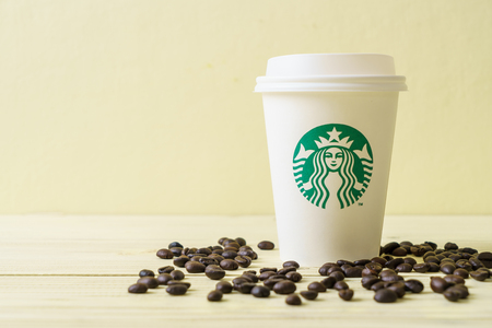BANGKOK, THAILAND - JUN 5, 2018: White coffee cup with Starbucks logo on wood background. Starbucks is the world's largest coffee house with over 20,000 stores in 61 countries.のeditorial素材
