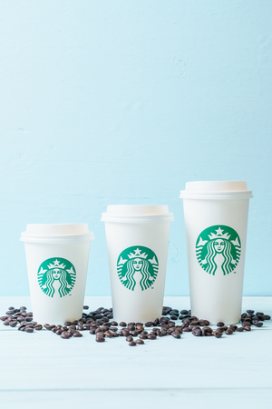 BANGKOK, THAILAND - JUN 5, 2018: White coffee cup with Starbucks logo on wood background. Starbucks is the world's largest coffee house with over 20,000 stores in 61 countries.のeditorial素材