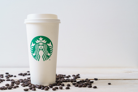 BANGKOK, THAILAND - JUN 5, 2018: White coffee cup with Starbucks logo on wood background. Starbucks is the world's largest coffee house with over 20,000 stores in 61 countries.のeditorial素材
