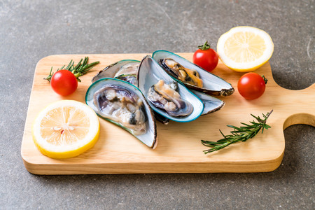 fresh mussels on wooden board with ingredientsの写真素材