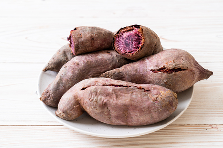 purple sweet potatoes on wood backgroundの写真素材