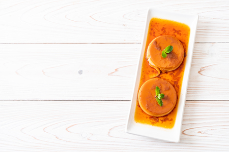 homemade caramel custard pudding on wood backgroundの写真素材