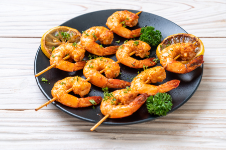 Grilled tiger shrimps skewers with lemon - seafood styleの写真素材