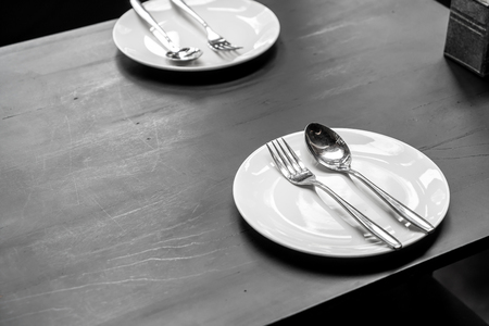 plate with spoon and fork on dining table in restaurant and cafeの写真素材