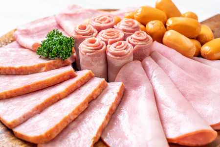 bacon, sausage, smoked ham and barbecue bacon on wood board