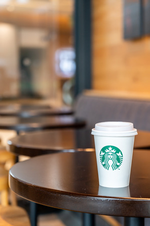 BANGKOK, THAILAND - June 29, 2018: Starbucks hot beverage coffee with holder on the table in Starbuck coffee shop.のeditorial素材