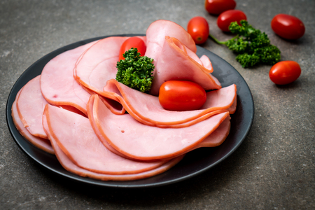 smoked ham sliced on plateの写真素材
