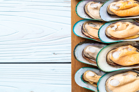 fresh mussel on wood board with ingredients