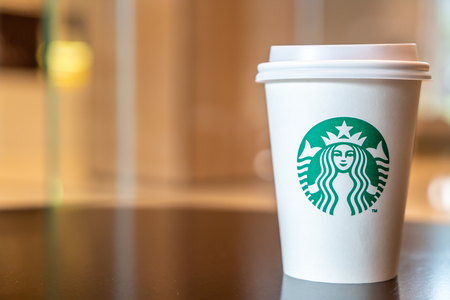BANGKOK, THAILAND - June 29, 2018: Starbucks hot beverage coffee with holder on the table in Starbuck coffee shop.のeditorial素材