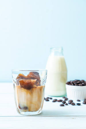 coffee ice cubes with milk on wood tableの写真素材