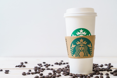 BANGKOK, THAILAND - JUN 5, 2018: White coffee cup with Starbucks logo on wood background. Starbucks is the world's largest coffee house with over 20,000 stores in 61 countries.のeditorial素材
