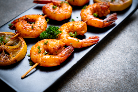 Grilled tiger shrimps skewers with lemon - seafood styleの写真素材