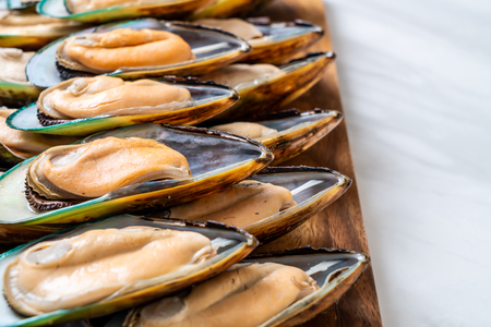 fresh mussel on wood board with ingredientsの写真素材