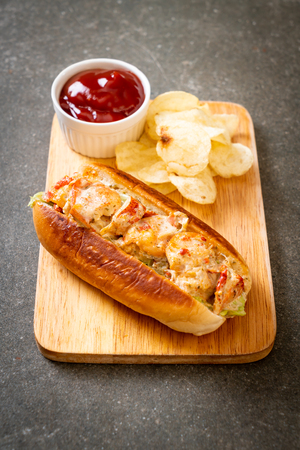homemade lobster roll with potato chips on wooden boardの写真素材