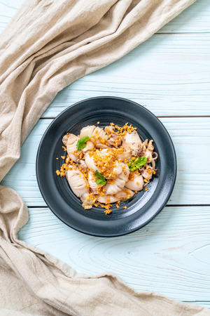 fried squid or octopus with garlic on plateの写真素材