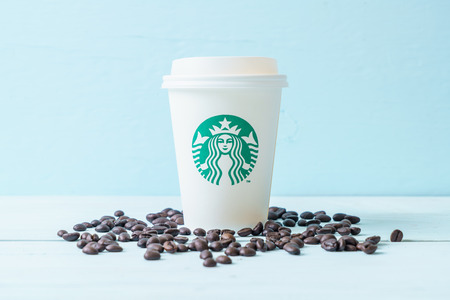BANGKOK, THAILAND - JUN 5, 2018: White coffee cup with Starbucks logo on wood background. Starbucks is the world's largest coffee house with over 20,000 stores in 61 countries.のeditorial素材