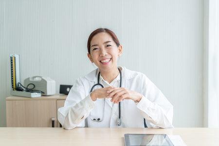 Asian female doctor smiling in officeの写真素材