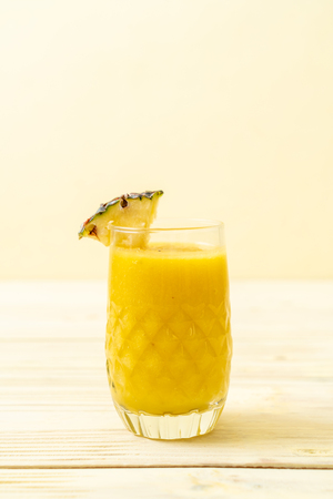 fresh pineapple smoothie glass on wood table - Healthy Drinkの写真素材