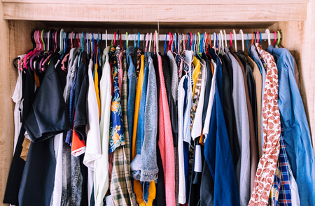 Hangers with different clothes in wardrobe closet - vintage light filterの写真素材