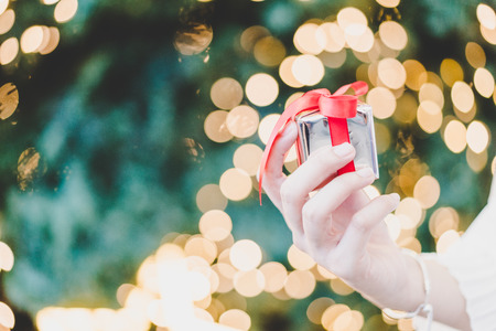 gift on hand with christmas bokeh light background - vintage effect filterの写真素材