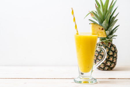 fresh pineapple smoothie glass on wood table - Healthy Drinkの写真素材