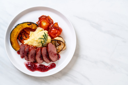 grilled duck breast with sauce, mash potatoes and vegetableの写真素材