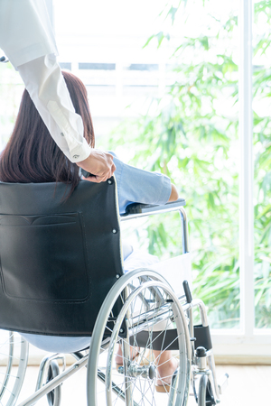 Asian female patient on wheelchair with senior doctorの写真素材