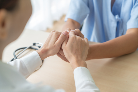 Hand of female doctor holding on her senior patient - selective focus pointの写真素材