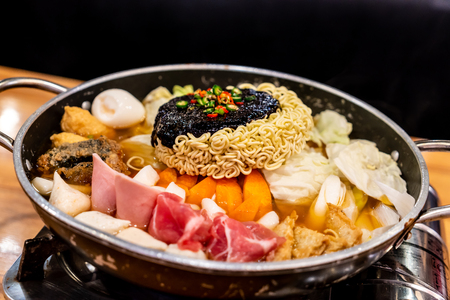 Korean Hot pot 'Budae Jjigae' is Korean fusion food incorporates American style with noodle, ham, sausages, sliced cheese and Kimchi.の写真素材