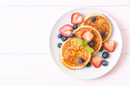 souffle pancake with fresh blueberries, fresh strawberries and honeyの写真素材