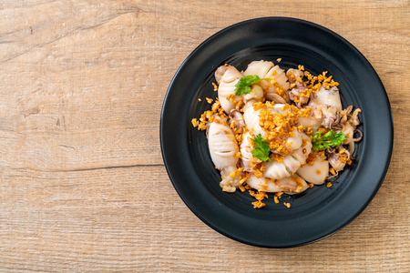 fried squid or octopus with garlic on plateの写真素材