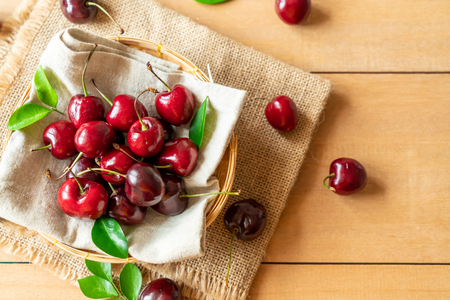 Fresh cherries in bowl  on wood backgroundの写真素材