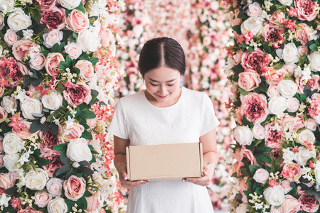Asian woman holding brown paper box on hand