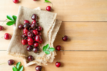 Fresh cherries in bowl  on wood backgroundの写真素材
