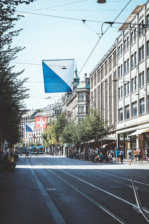 ZURICH, SWITZERLAND - AUG 23, 2018: A tram drives down the center of Bahnhofstrasse while people walk on the sidewalks in Zurich City, Switzerland.のeditorial素材