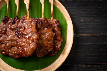 grilled skewered milk pork with white sticky rice - local Thai street food styleの写真素材