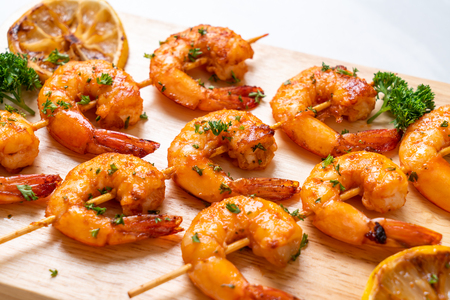 Grilled tiger shrimps skewers with lemon - seafood styleの写真素材