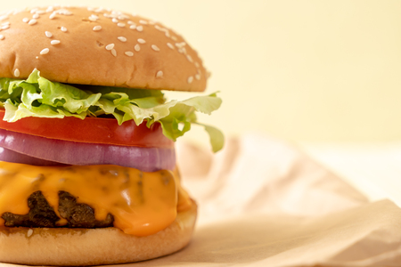 fresh tasty beef burger with cheese and french fries on wood backgroundの写真素材
